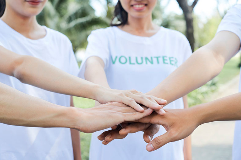 volunteers with hands in